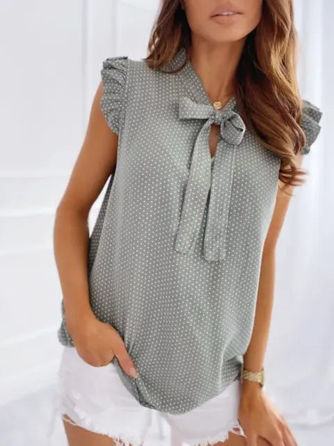 Women's summery sleeveless blouse with polka dots, ruffles and bow detail